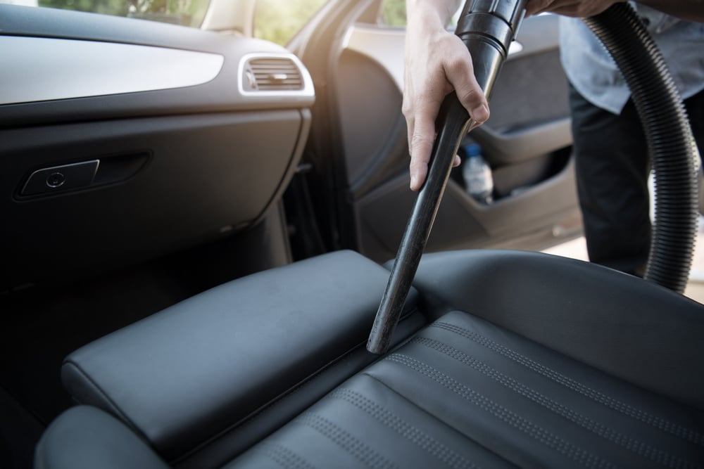 Man Using Car Vacuum Cleaner to Clean Car